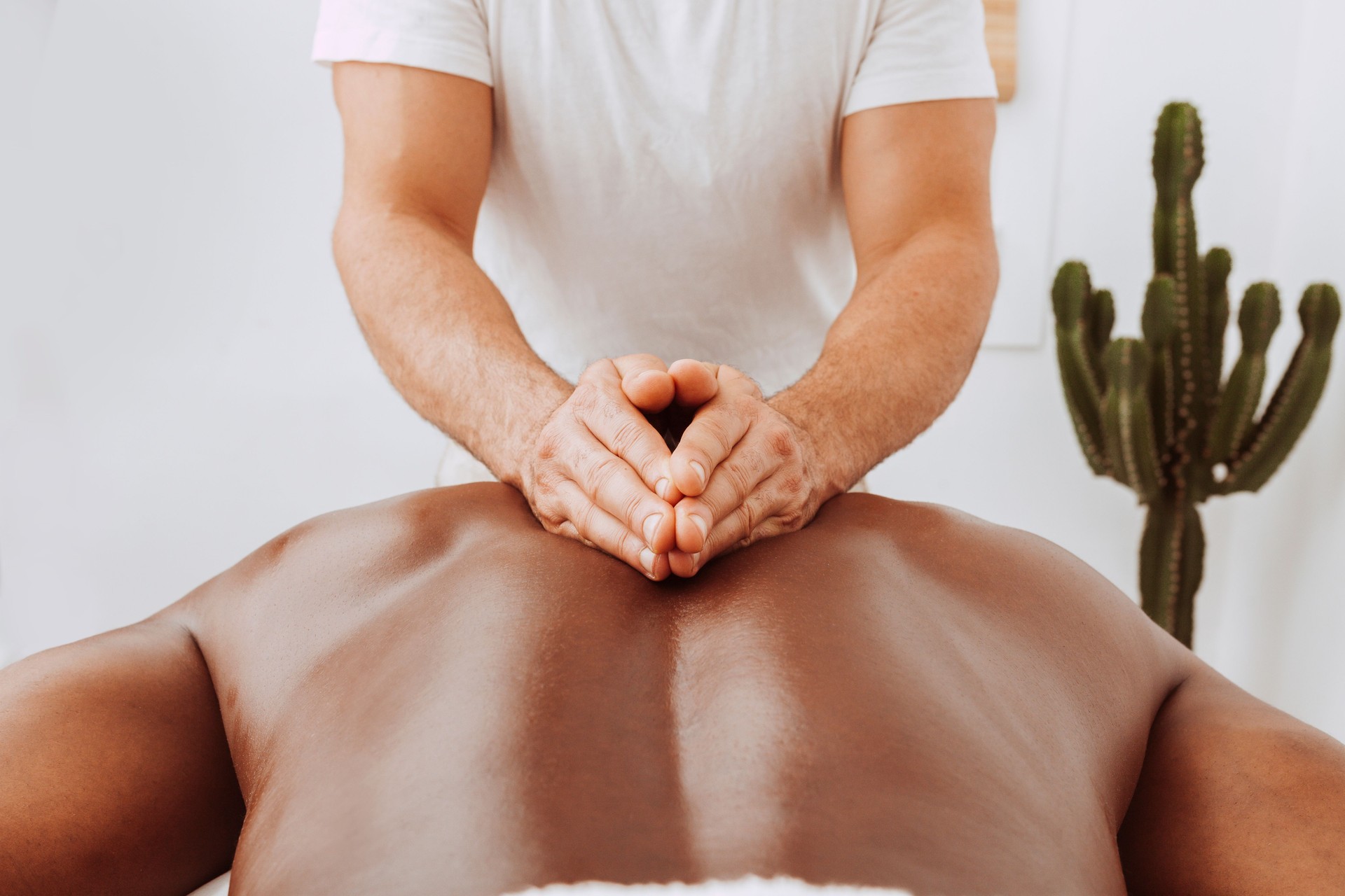Therapist doing healing treatment on black man's back